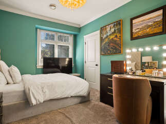 This inviting bedroom features a plush, upholstered bed and a large window providing ample natural light.
