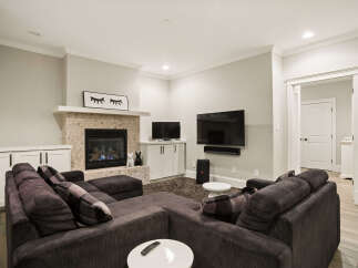 Experience ultimate relaxation in this cozy living room, featuring a modern sectional sofa perfect for family gatherings.