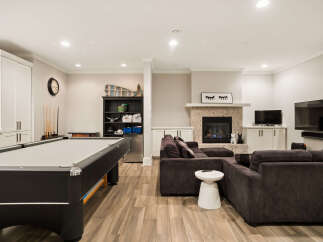 This finished basement offers the ultimate entertainment space, featuring a full-size pool table and a cozy living area centered around a modern fireplace.