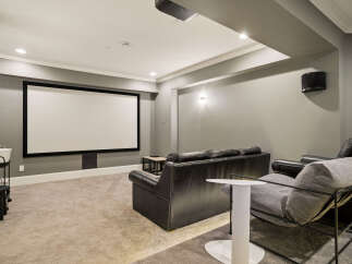 Experience cinematic bliss in this dedicated home theater, featuring a large projection screen and comfortable seating for an immersive viewing experience.