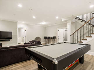 Enjoy endless entertainment in this finished basement, complete with a full-size pool table and a comfortable sectional sofa perfect for movie nights.