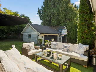 Enjoy outdoor living in this spacious backyard featuring a comfortable patio set perfect for entertaining.