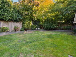 Enjoy the lush green lawn and mature trees in this private backyard oasis.