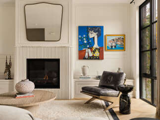 Experience sophisticated living in this beautifully appointed living room, featuring a modern fireplace with fluted detailing and a large, stylish mirror.