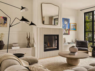 This living room features a modern fireplace with fluted detailing, complemented by abstract art and a large abstract painting.