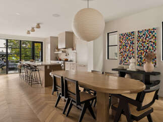Experience modern living in this open-concept kitchen and dining area, featuring a large island with bar seating and a spacious dining table perfect for gatherings.