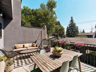 Enjoy outdoor living on this spacious balcony featuring a comfortable seating area with a sofa and coffee table, perfect for relaxing.