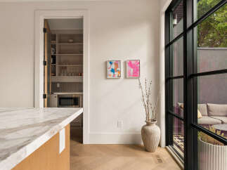Experience modern living with this stunning kitchen featuring a sleek marble countertop and a convenient walk-in pantry.