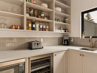 Discover this beautifully organized pantry, featuring ample shelving for all your culinary needs.