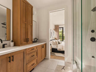 Experience modern luxury in this stunning bathroom featuring a sleek vanity with ample storage and a spacious walk-in shower with elegant tilework.