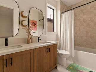 This modern bathroom features a double vanity with sleek black fixtures and ample storage.