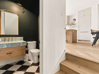 Step into a beautifully designed powder room featuring a striking marble vanity and a classic black and white checkered floor.