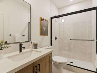 Experience modern elegance in this beautifully appointed bathroom, featuring a sleek vanity with a black faucet and a spacious undermount sink.
