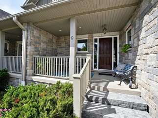 Welcome guests to this charming home with a welcoming covered porch featuring a classic wooden door and a decorative bench.
