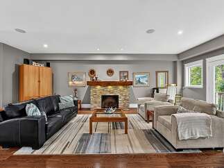 This inviting living room features a cozy stone fireplace as the focal point, perfect for gathering with loved ones.