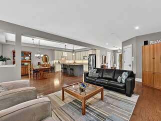 Experience open-concept living in this beautifully appointed home, featuring a spacious living area flowing seamlessly into a modern kitchen and dining space.
