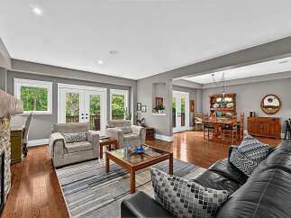 This spacious open-concept living and dining area features a cozy fireplace, comfortable seating, and a large dining table perfect for family gatherings.