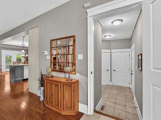 Step into this inviting entryway featuring a charming wooden cabinet with a decorative mirror above, perfect for adding a touch of warmth.