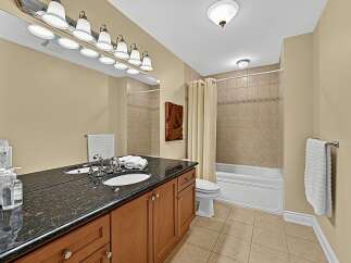 This elegant bathroom features a spacious vanity with a granite countertop and dual sinks, perfect for busy mornings.