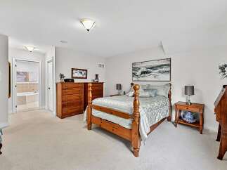 This charming bedroom features a cozy wooden bed with a patterned comforter, complemented by two matching nightstands and lamps.