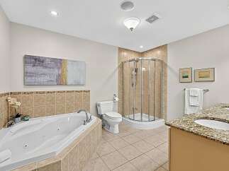 Indulge in luxury with this stunning bathroom featuring a spacious corner jacuzzi tub perfect for relaxation.