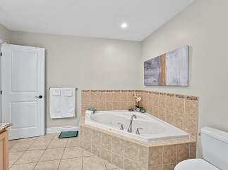Indulge in relaxation in this luxurious bathroom featuring a spacious corner jacuzzi tub, perfect for unwinding after a long day.