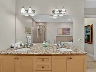 This elegant bathroom features a spacious double vanity with a granite countertop and ample storage.