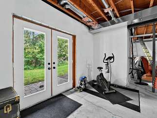 This basement space offers a versatile home gym setup, complete with an exercise bike and free weights, perfect for your fitness routine.