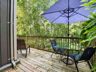 Enjoy your morning coffee or evening relaxation on this charming wooden deck, complete with a glass-top table and comfortable seating.