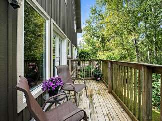 Enjoy your morning coffee on this charming wooden deck, surrounded by lush greenery.