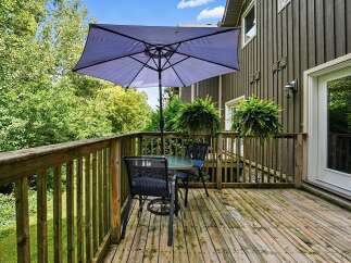 Enjoy outdoor living on this charming deck, perfect for al fresco dining or relaxing with a view of the lush greenery.