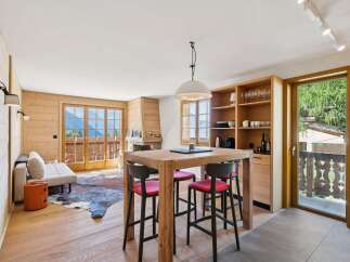 Experience alpine living in this charming mountain retreat, featuring a cozy living area with a fireplace and stunning panoramic views from the balcony.