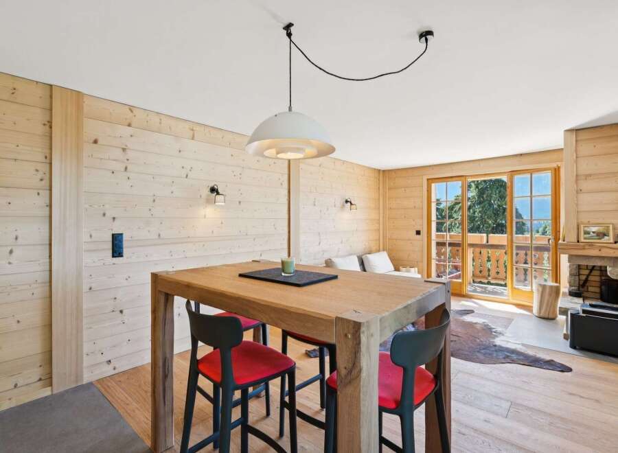 Experience cozy living in this charming alpine retreat, featuring warm wood paneling throughout and a rustic stone fireplace.