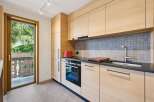 Experience modern living in this beautifully appointed kitchen, featuring sleek light wood cabinetry and a stylish grey tiled backsplash.
