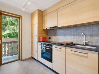 Experience modern living in this beautifully appointed kitchen, featuring sleek light wood cabinetry and a stylish grey tiled backsplash.