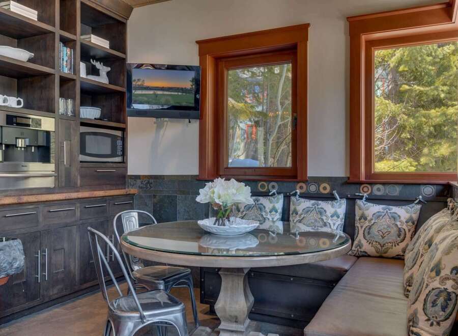 Enjoy cozy meals in this charming breakfast nook featuring a round glass-top table and comfortable built-in seating.