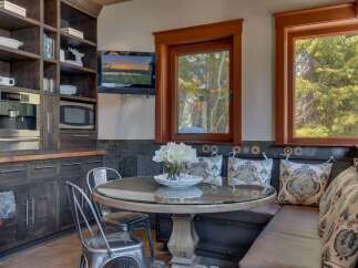 Enjoy cozy meals in this charming breakfast nook featuring a round glass-top table and comfortable built-in seating.