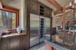 Experience luxury living in this stunning kitchen featuring a built-in stainless steel refrigerator and wine cooler, complemented by rich dark wood cabinetry.