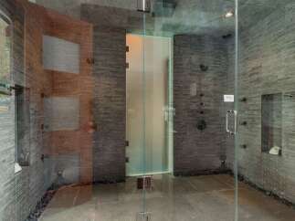 Experience ultimate relaxation in this luxurious spa-like shower featuring multiple shower heads and a sleek glass enclosure.