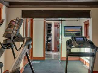 Elevate your fitness routine in this dedicated home gym, featuring a NordicTrack elliptical and a treadmill.
