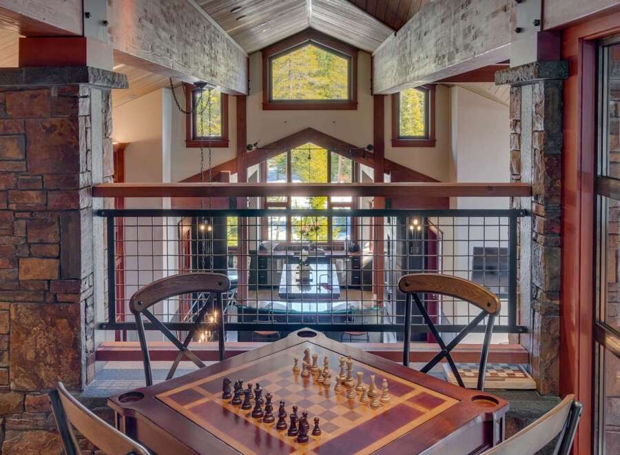 Experience luxury mountain living in this stunning home featuring a dedicated game room with a chess table, perfect for evening entertainment.