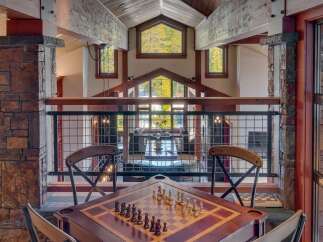 Experience luxury mountain living in this stunning home featuring a dedicated game room with a chess table, perfect for evening entertainment.