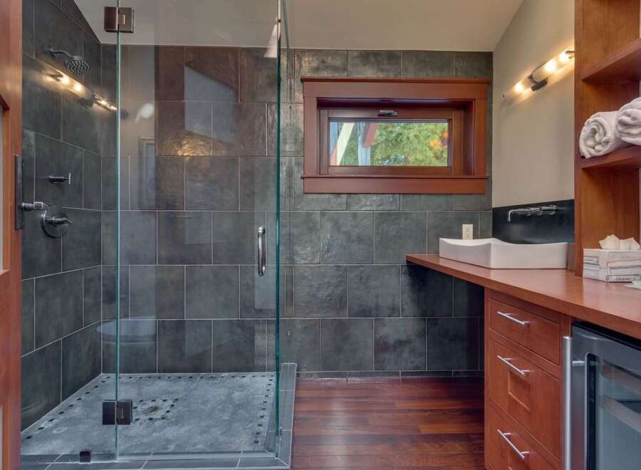 Experience modern luxury in this stunning bathroom featuring a spacious glass-enclosed shower with slate tile accents.