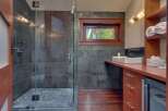 Experience modern luxury in this stunning bathroom featuring a spacious glass-enclosed shower with slate tile accents.