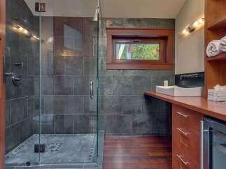 Experience modern luxury in this stunning bathroom featuring a spacious glass-enclosed shower with slate tile accents.