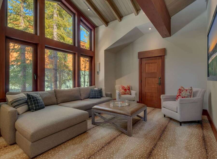 Experience luxurious mountain living in this stunning living room, featuring a grand sectional sofa and a stylish leather ottoman perfect for gatherings.