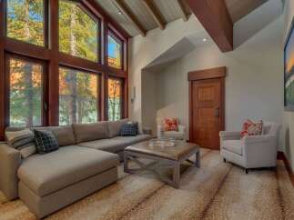 Experience luxurious mountain living in this stunning living room, featuring a grand sectional sofa and a stylish leather ottoman perfect for gatherings.
