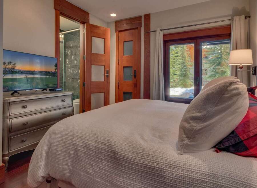 Experience ultimate comfort in this beautifully appointed bedroom, featuring a plush bed and a modern dresser with an integrated TV.