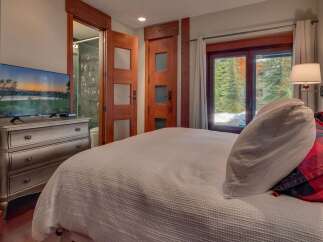 Experience ultimate comfort in this beautifully appointed bedroom, featuring a plush bed and a modern dresser with an integrated TV.