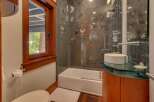 Experience luxury in this modern bathroom featuring a sleek glass-enclosed shower with unique fossil-inspired tilework.
